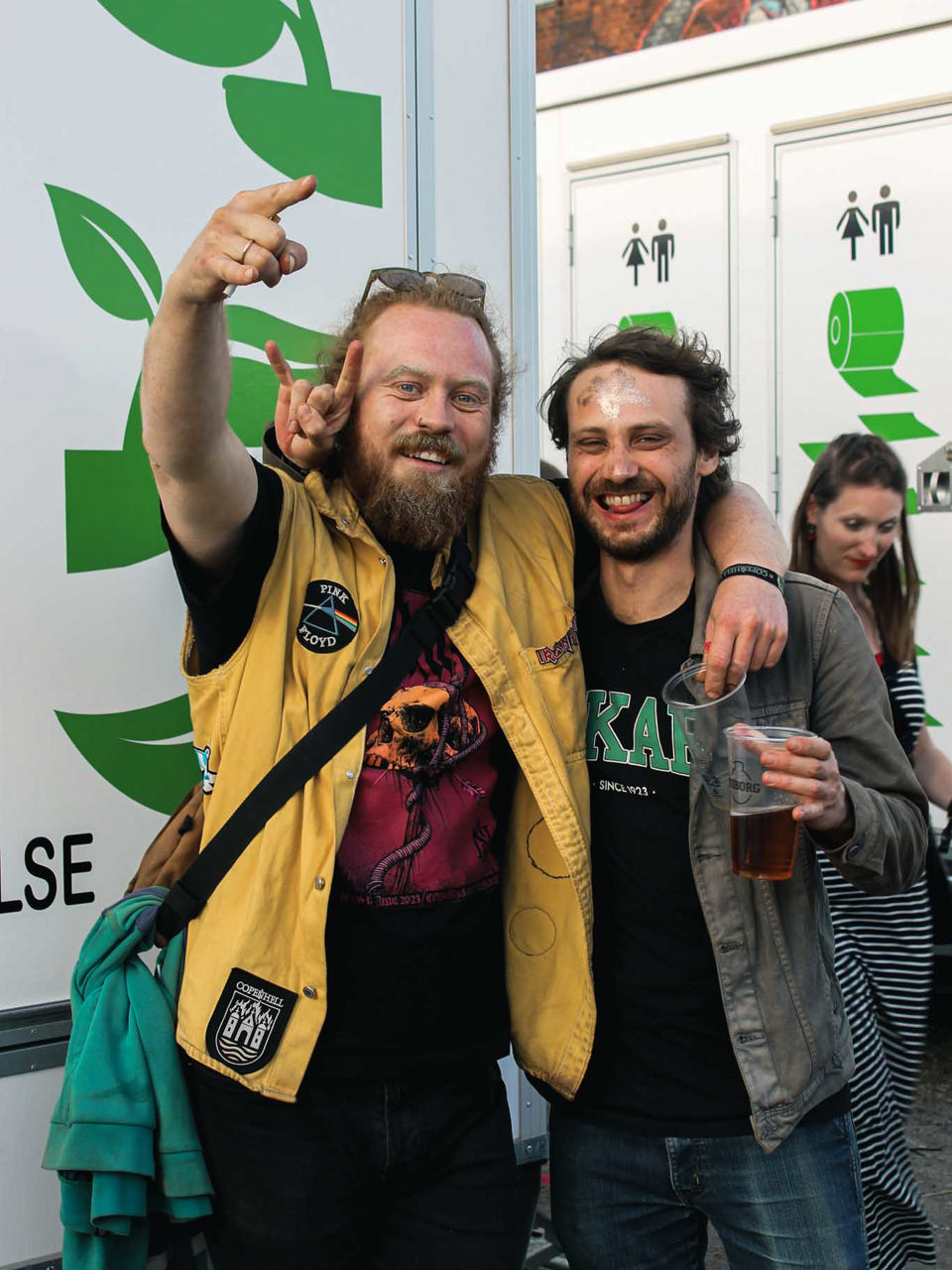 Festivalgæster foran Godiks miljøvenlige toiletvogne med fokus på vandbesparende vakuumteknologi