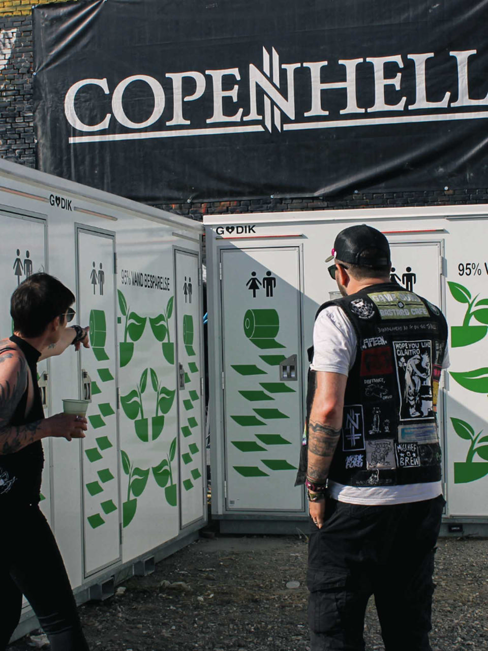 To festivalgæster foran godik toiletmoduler