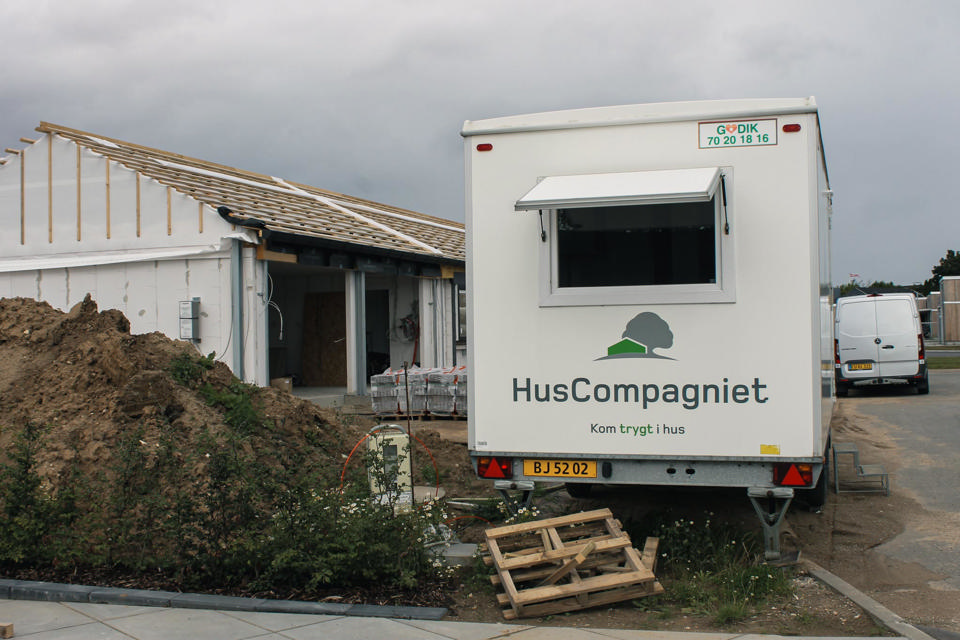 En godik mandskabsvogn med HusCompagniet folieret branding på gavlen